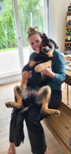 Linda sitzt mit Akay auf dem Schoss auf einer Bank